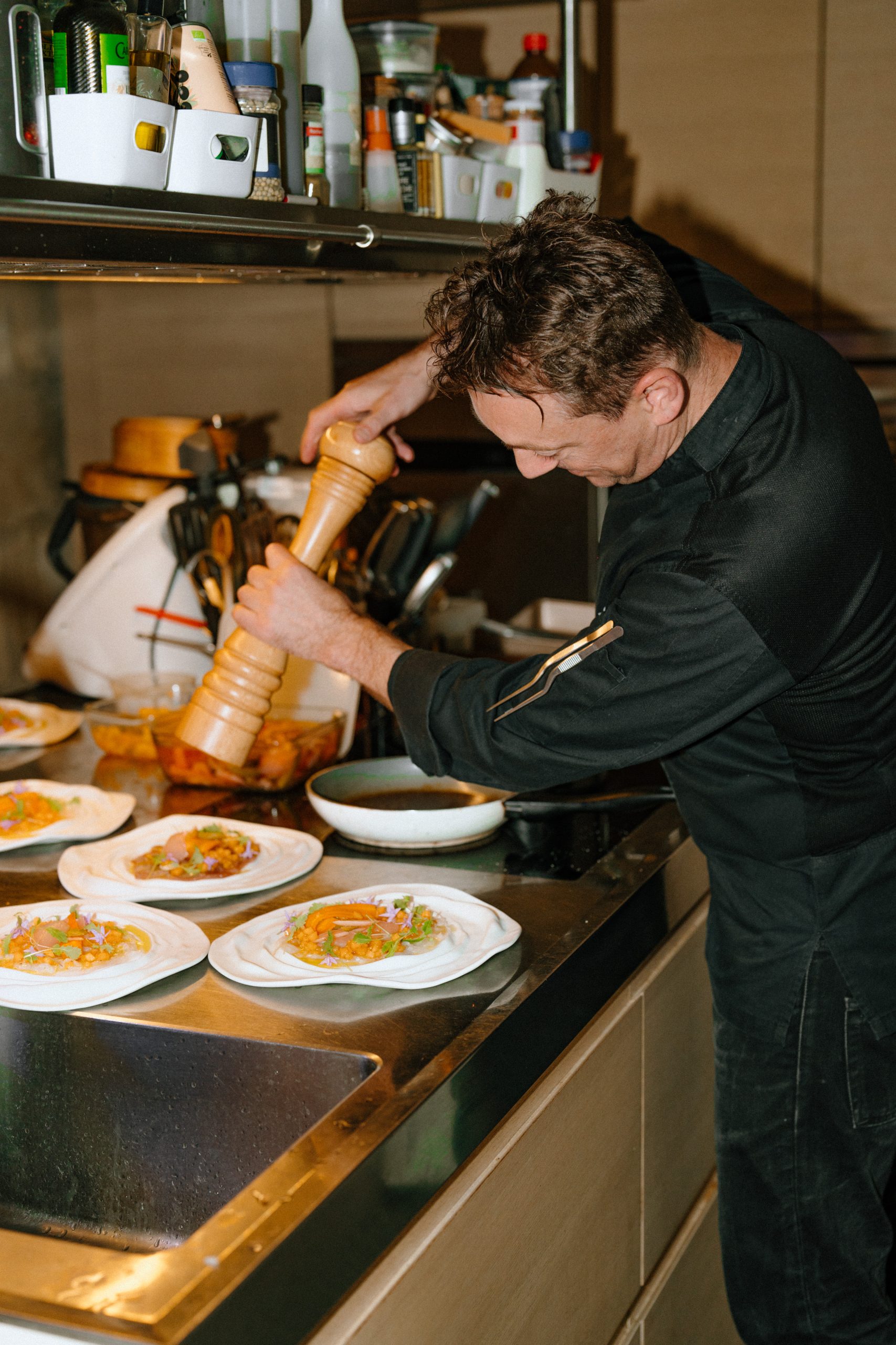 Un chef assaisonne une préparation avec précision