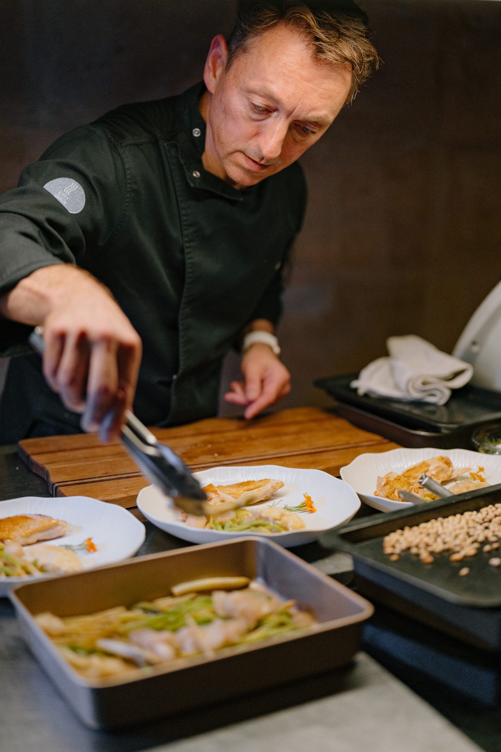 Un chef dresse avec précision les assiettes d’un dîner À L’ADRESSE